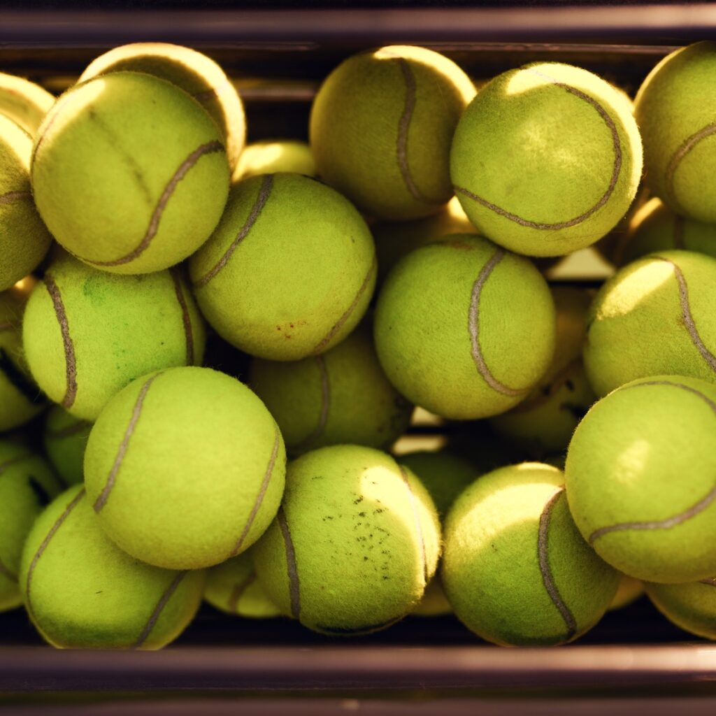 Basket with big tennis balls, top view, nobody