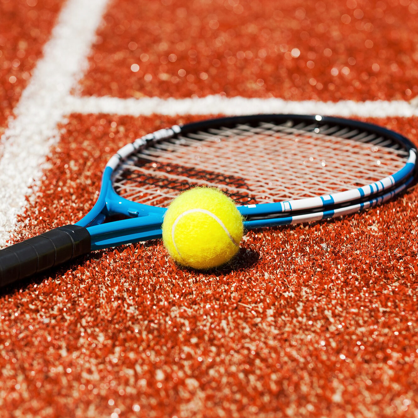 Play tennis? Close-up of tennis racket and tennis ball laying on the court